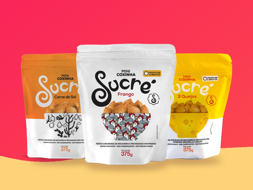 Três embalagens de mini coxinha Sucré, sabores carne de sol, frango e 3 queijos, sobre o degradê rosa da marca