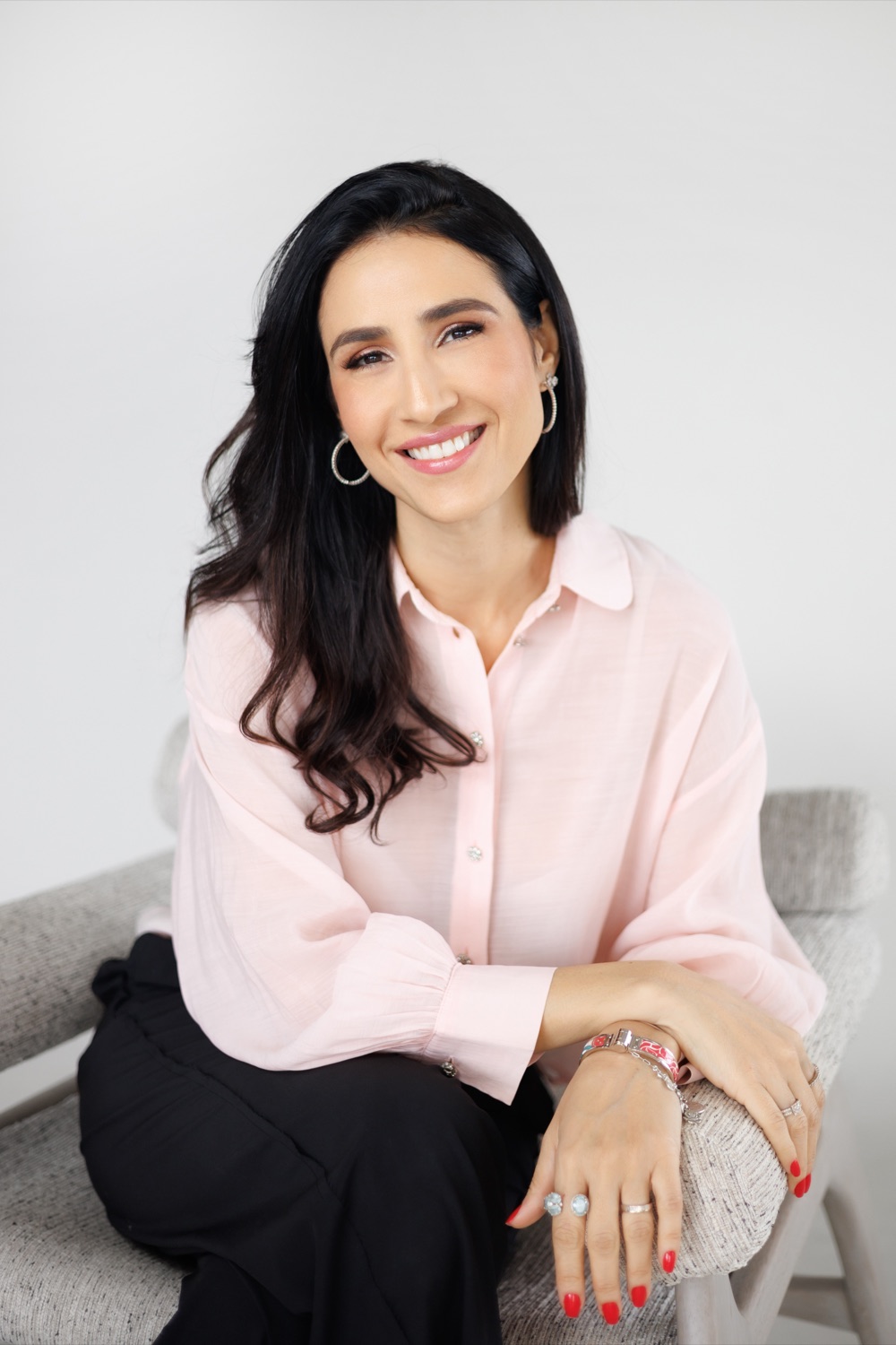 Lia Quinderé, fundadora da Sucré, sorrindo de camisa rosa